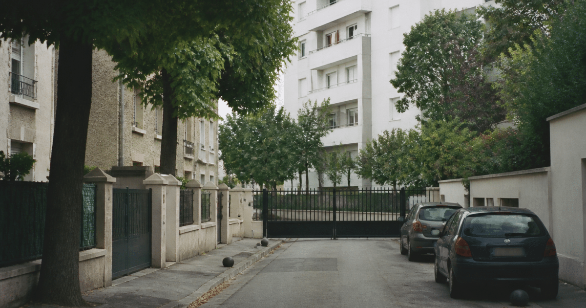 Rue urbaine de banlieue parisienne avec immeubles résidentiels fermés