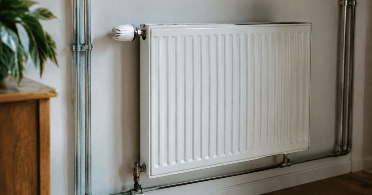 Radiateur mural vibrant avec tuyauterie metallique visible en arriere-plan