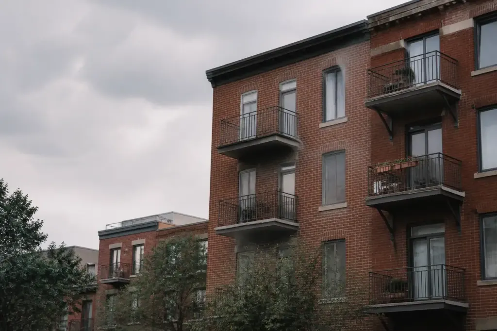 Immeubles en briques rouges avec balcons sous ciel gris