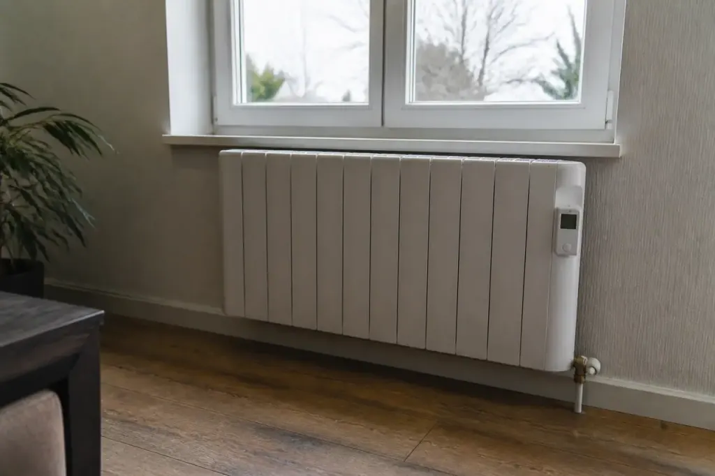 Radiateur blanc avec thermostat digital fixe sous une fenetre