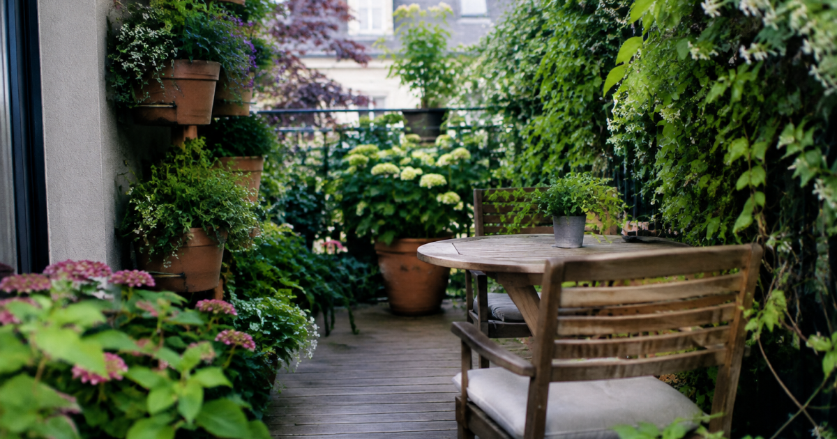 Terrasse fleurie avec pots verticaux et plantes grimpantes denses