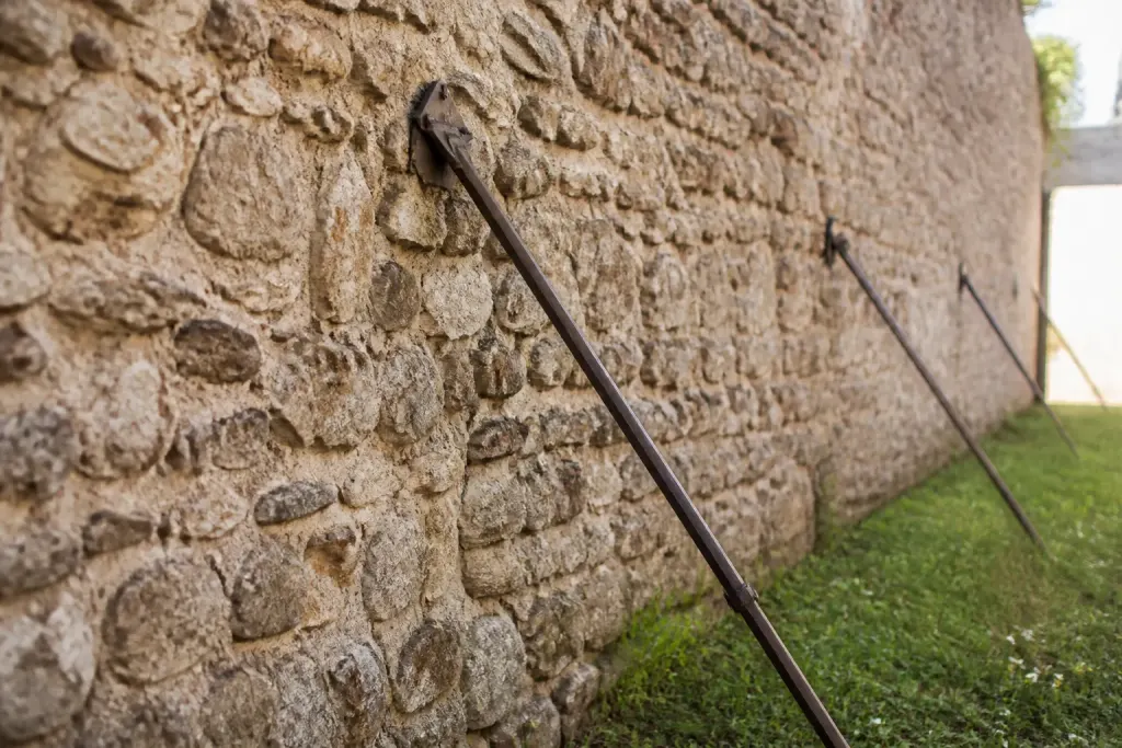 Vieux mur de pierre etaye par des tiges metalliques